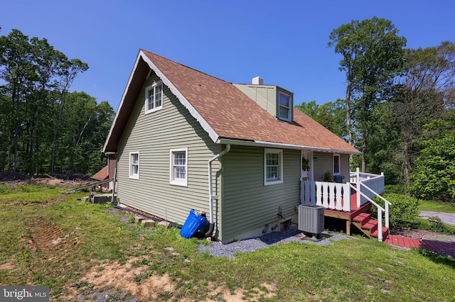 402 Swamp Rd, Morgantown, PA 19543 - rear view of house with central AC unit, a yard, a shingled roof, and a chimney