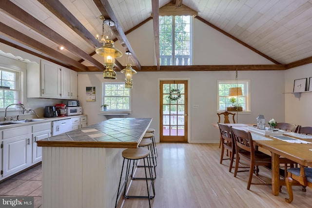 402 Swamp Rd, Morgantown, PA 19543 - kitchen with a sink, tile counters, white cabinets, white appliances, and a kitchen breakfast bar