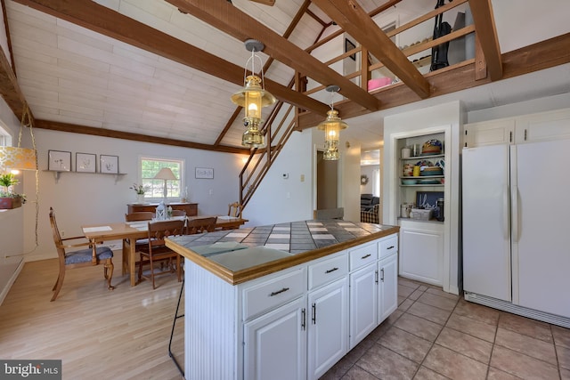 402 Swamp Rd, Morgantown, PA 19543 - kitchen featuring freestanding refrigerator, tile counters, white cabinets, and hanging light fixtures