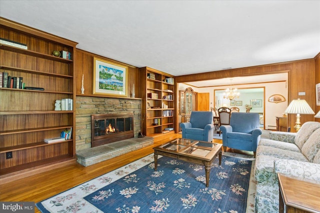 161 Bull Run Rd, Pennington, NJ 08534 - living room with wood finished floors, a chandelier, a stone fireplace, wood walls, and a baseboard radiator