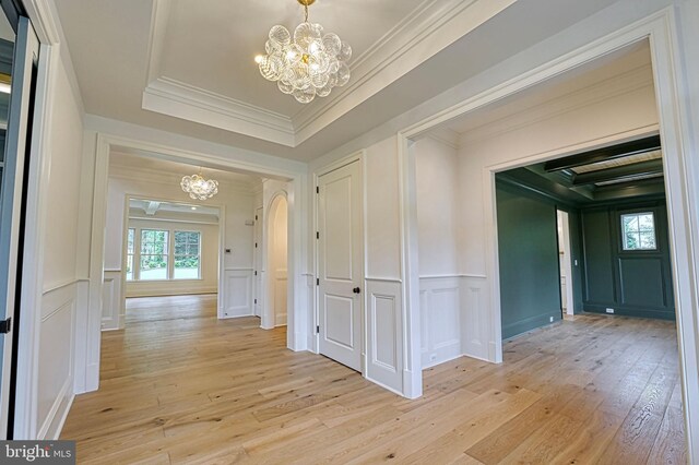 4740 34th Rd N, Arlington, VA 22207 - hallway featuring a chandelier, a decorative wall, light wood-style floors, arched walkways, and ornamental molding