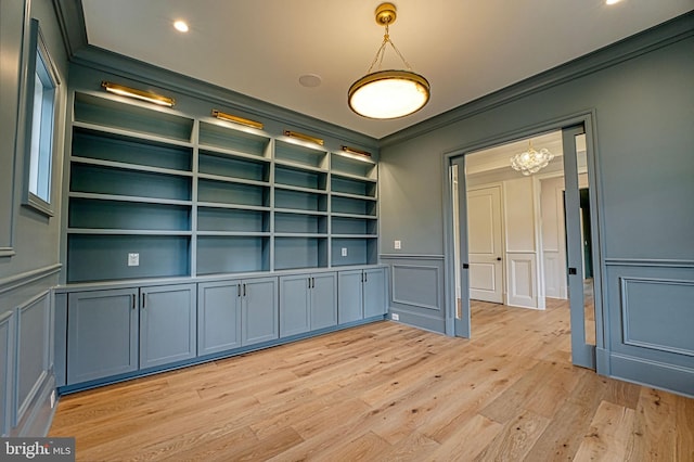 4740 34th Rd N, Arlington, VA 22207 - spare room with a decorative wall, crown molding, built in shelves, light wood-style floors, and a chandelier