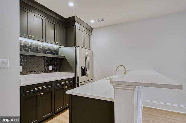 4740 34th Rd N, Arlington, VA 22207 - kitchen with a sink, tasteful backsplash, light wood-style floors, stainless steel fridge with ice dispenser, and light countertops