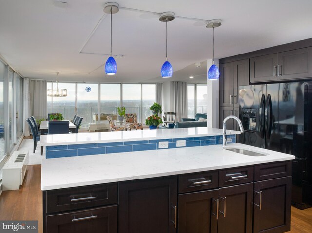 3900 Ford Rd Unit 21E & 20E, Philadelphia, PA 19131 - kitchen featuring a sink, black fridge with ice dispenser, a kitchen island with sink, hanging light fixtures, and wood finished floors