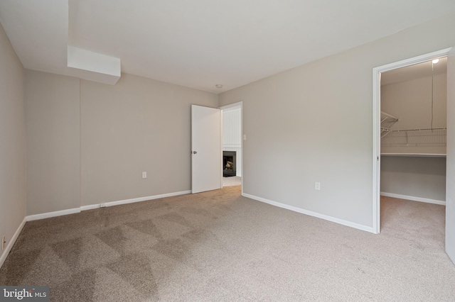 10528 Cross Fox Ln Unit D-2, Columbia, MD 21044 - unfurnished bedroom featuring a fireplace, carpet floors, a walk in closet, and baseboards