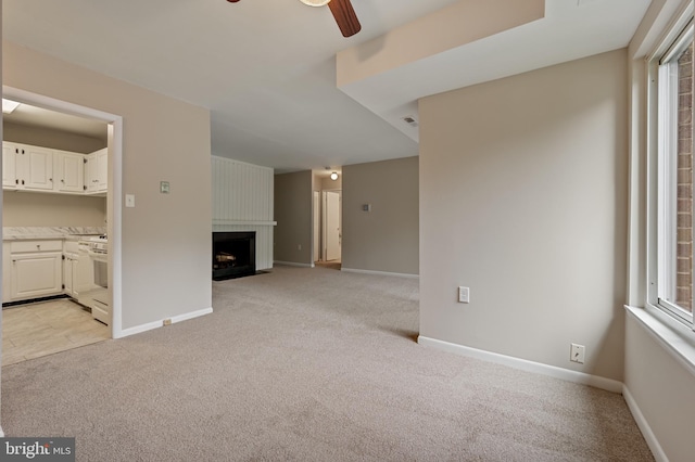 10528 Cross Fox Ln Unit D-2, Columbia, MD 21044 - unfurnished living room featuring light colored carpet, a ceiling fan, a large fireplace, and baseboards