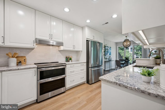 5071 Columbia Rd, Columbia, MD 21044 - kitchen featuring stainless steel appliances, under cabinet range hood, white cabinetry, light wood-type flooring, and recessed lighting