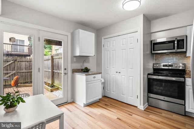 7556 S Arbory Ln Unit 382, Laurel, MD 20707 - kitchen with stainless steel appliances, light wood-style flooring, white cabinets, and decorative backsplash