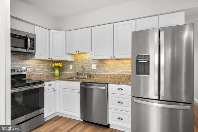 7556 S Arbory Ln Unit 382, Laurel, MD 20707 - kitchen with appliances with stainless steel finishes, white cabinets, light wood-type flooring, and dark stone counters