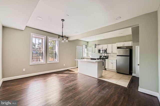 3711 Spaulding Ave, Baltimore, MD 21215 - kitchen with appliances with stainless steel finishes, white cabinetry, light wood-type flooring, light countertops, and a chandelier