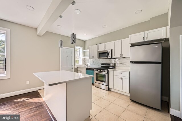 3711 Spaulding Ave, Baltimore, MD 21215 - kitchen with stainless steel appliances, light countertops, plenty of natural light, white cabinetry, and beam ceiling