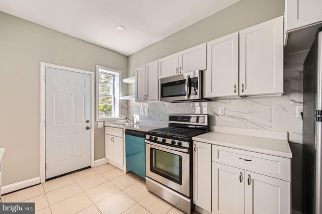 3711 Spaulding Ave, Baltimore, MD 21215 - kitchen with stainless steel appliances, white cabinets, light countertops, a sink, and tasteful backsplash