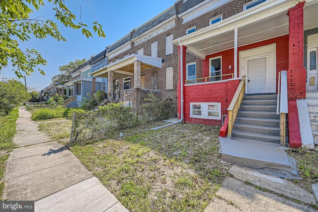 3711 Spaulding Ave, Baltimore, MD 21215 - view of front of house with brick siding, a porch, and a residential view