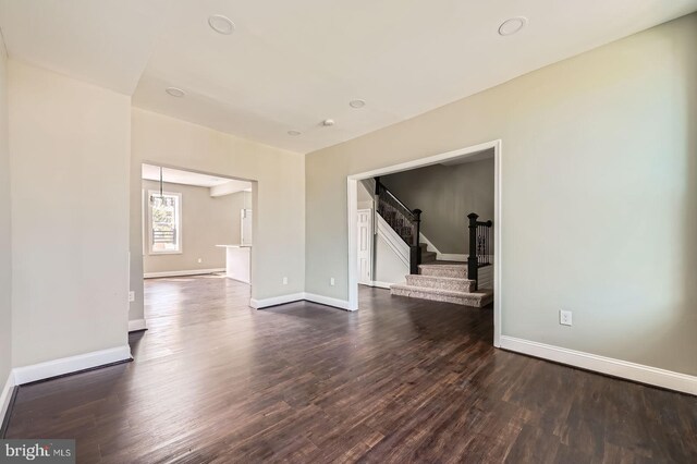 3711 Spaulding Ave, Baltimore, MD 21215 - spare room featuring stairs, dark wood-type flooring, and baseboards