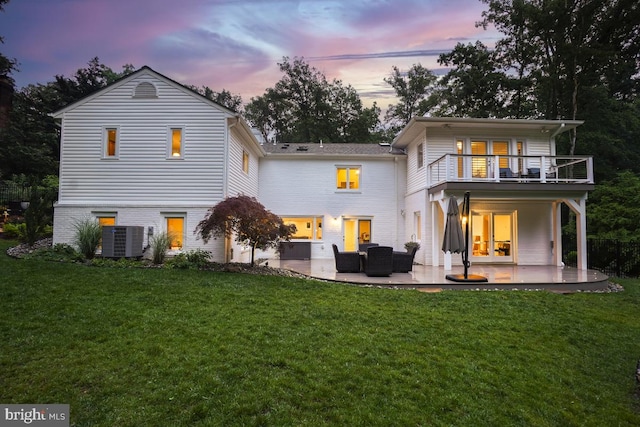 4604 Park Rd, Alexandria, VA 22312 - back of house at dusk with a balcony, a patio area, a lawn, and outdoor lounge area