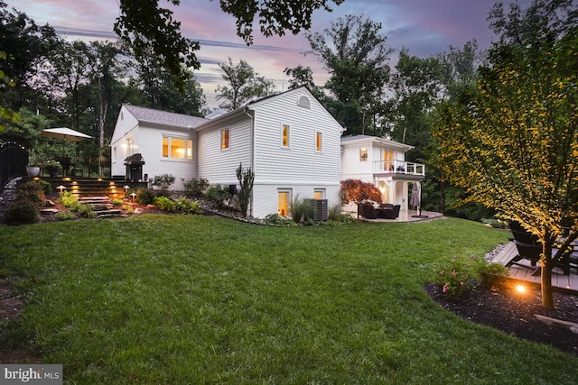 4604 Park Rd, Alexandria, VA 22312 - back of property at dusk with a balcony, a lawn, and a patio area