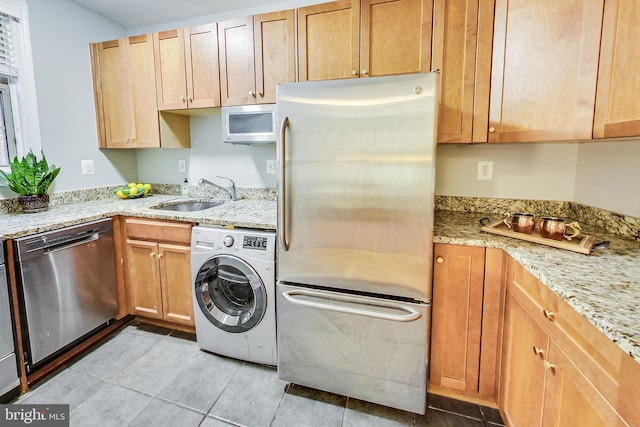 1441 Euclid St NW Unit 105, Washington, DC 20009 - kitchen featuring stainless steel appliances, washer / clothes dryer, a sink, light tile patterned floors, and light stone countertops