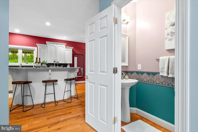 10840 Wolfsville Rd, Myersville, MD 21773 - kitchen featuring a kitchen breakfast bar, white cabinets, light wood-style floors, a peninsula, and recessed lighting