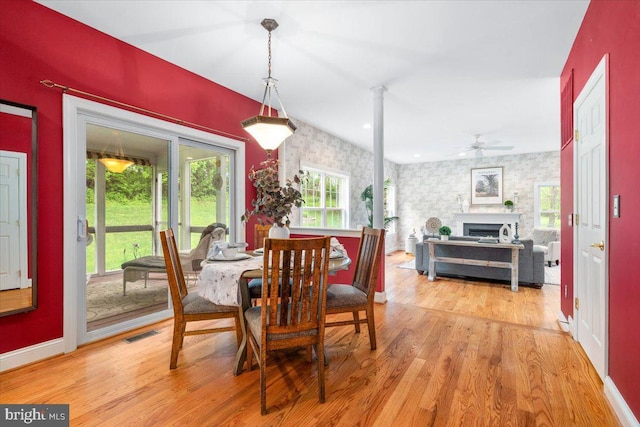10840 Wolfsville Rd, Myersville, MD 21773 - dining space featuring wallpapered walls, baseboards, light wood-type flooring, an accent wall, and a fireplace