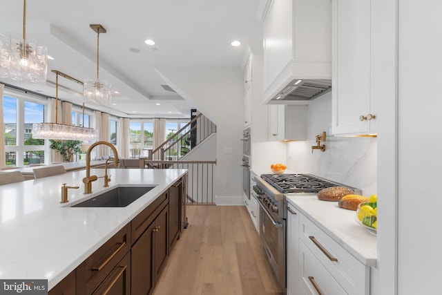 1632 Chain Bridge Rd, Mclean, VA 22101 - kitchen with custom range hood, a sink, appliances with stainless steel finishes, dark brown cabinetry, and light wood-style flooring