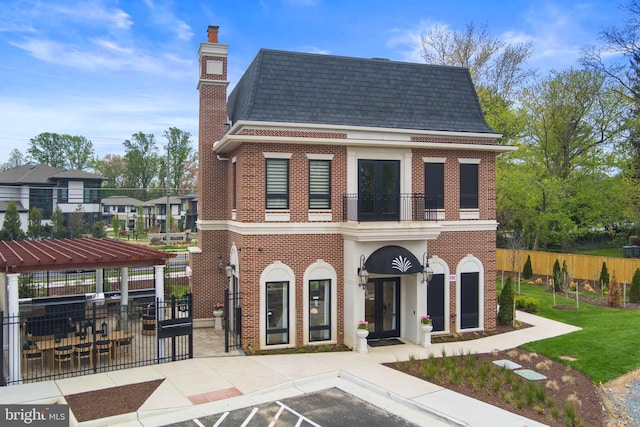 1632 Chain Bridge Rd, Mclean, VA 22101 - view of front of house with french doors, a balcony, brick siding, and a shingled roof