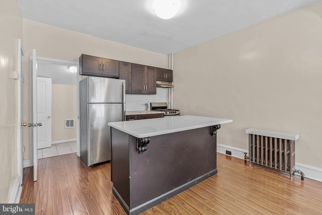 159 W Palmer St, Philadelphia, PA 19122 - kitchen featuring freestanding refrigerator, stove, dark brown cabinets, wood finished floors, and under cabinet range hood
