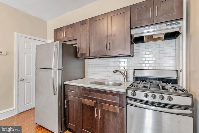 159 W Palmer St, Philadelphia, PA 19122 - kitchen featuring stainless steel appliances, a sink, under cabinet range hood, and dark brown cabinets