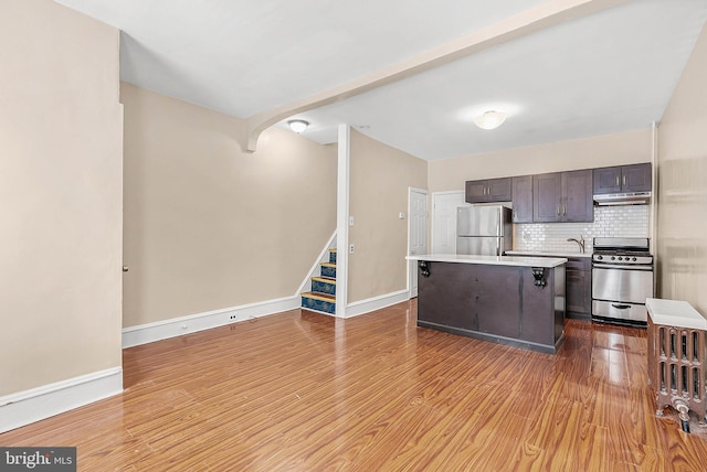 159 W Palmer St, Philadelphia, PA 19122 - kitchen with appliances with stainless steel finishes, dark brown cabinetry, a center island, and wood finished floors