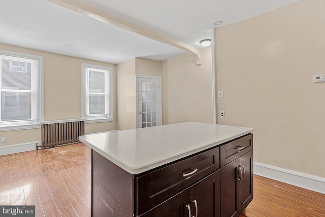159 W Palmer St, Philadelphia, PA 19122 - kitchen featuring radiator heating unit, light wood-style flooring, dark brown cabinets, light countertops, and baseboards