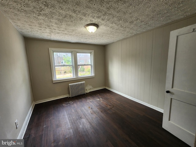 1609 Spruce St, Baltimore City, MD 21226 - empty room featuring radiator heating unit, dark wood-type flooring, and baseboards