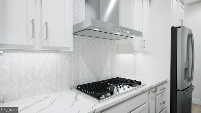 23640 Bolton Crescent Ter Unit 13-306, Ashburn, VA 20148 - kitchen with wall chimney range hood, stainless steel appliances, white cabinetry, tasteful backsplash, and light stone counters