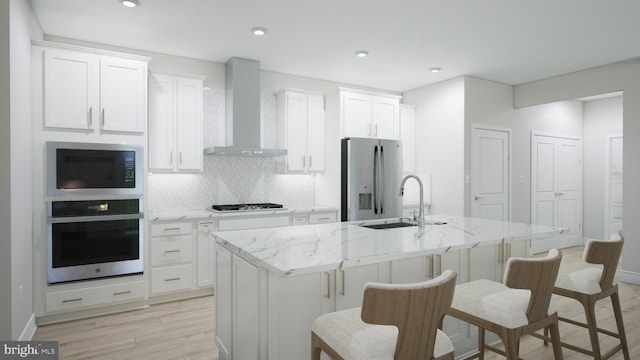 23640 Bolton Crescent Ter Unit 13-306, Ashburn, VA 20148 - kitchen with stainless steel appliances, wall chimney range hood, a sink, a kitchen island with sink, and decorative backsplash