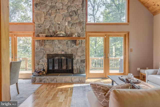 2020 Quaint Acres Ln, Berkeley Springs, WV 25411 - living area featuring wood finished floors, vaulted ceiling, a fireplace, and french doors