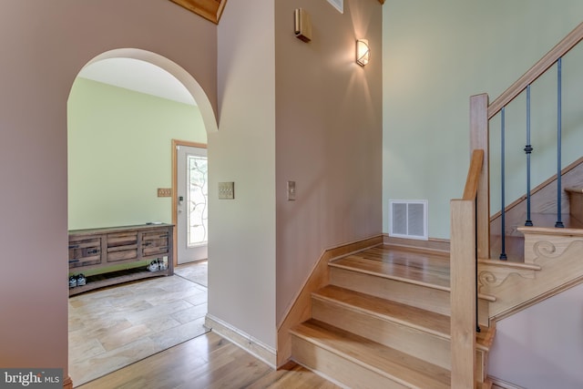 2020 Quaint Acres Ln, Berkeley Springs, WV 25411 - stairway with arched walkways, baseboards, and a towering ceiling