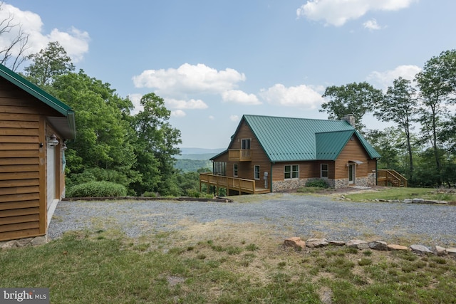 2020 Quaint Acres Ln, Berkeley Springs, WV 25411 - view of front facade featuring stone siding, a chimney, a deck, metal roof, and a front yard