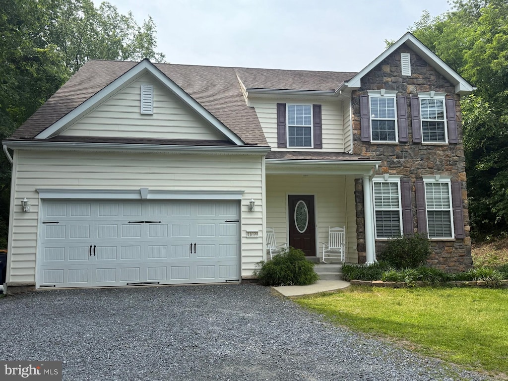 41699 Courthouse Dr, Leonardtown, MD 20650 - traditional-style house with stone siding, gravel driveway, a garage, and roof with shingles