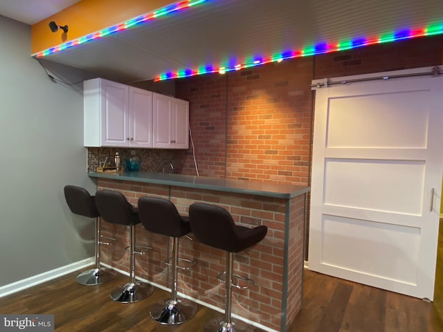 614 Empire Dr, Downingtown, PA 19335 - bar area with dark wood-type flooring, baseboards, and backsplash