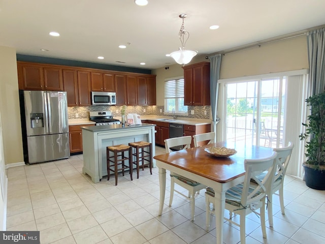 614 Empire Dr, Downingtown, PA 19335 - kitchen with stainless steel appliances, a sink, decorative backsplash, a kitchen island, and pendant lighting