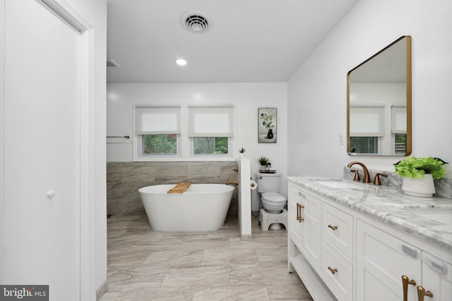 8170 Sinclair Mill Rd, Manassas, VA 20112 - bathroom with vanity, a freestanding bath, toilet, marble finish floors, and tile walls