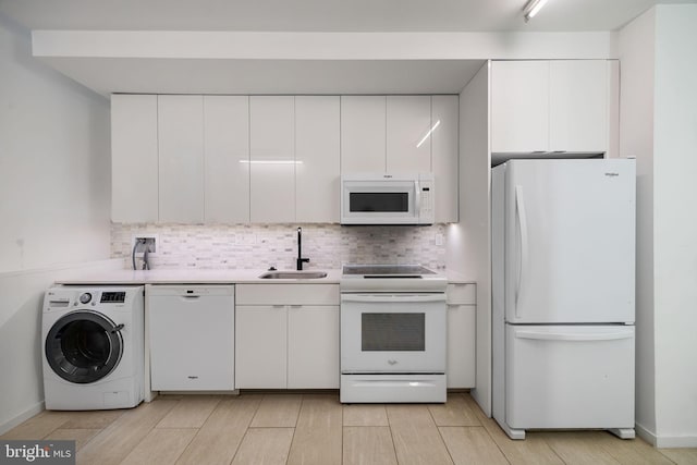 2710 W Harper St, Philadelphia, PA 19130 - kitchen with white appliances, washer / clothes dryer, white cabinets, and backsplash