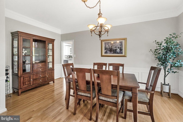 202 Galyn Dr, Brunswick, MD 21758 - dining area featuring a chandelier, light wood-style floors, crown molding, wainscoting, and a decorative wall