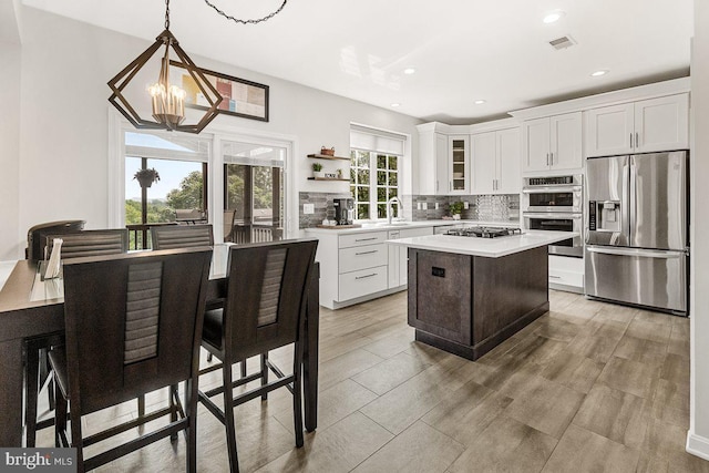202 Galyn Dr, Brunswick, MD 21758 - kitchen featuring stainless steel appliances, a chandelier, a kitchen island, decorative backsplash, and light countertops