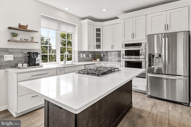 202 Galyn Dr, Brunswick, MD 21758 - kitchen featuring appliances with stainless steel finishes, a sink, white cabinets, tasteful backsplash, and light wood-type flooring