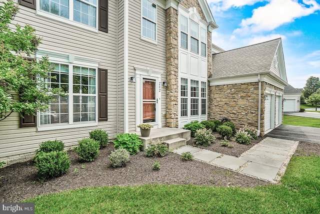 202 Galyn Dr, Brunswick, MD 21758 - doorway to property featuring stone siding, a shingled roof, an attached garage, and asphalt driveway