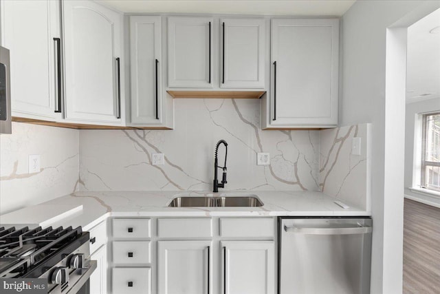1701 Gainesville St SE Unit 101, Washington, DC 20020 - kitchen featuring stainless steel dishwasher, a sink, backsplash, and white cabinetry