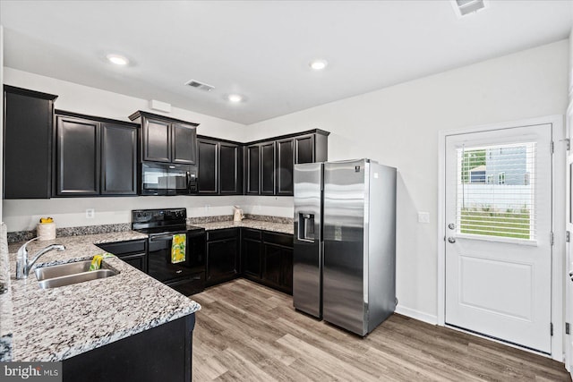 17324 Mary Adams Ave, Bowling Green, VA 22427 - kitchen with black appliances, a sink, dark cabinetry, light stone counters, and light wood-type flooring