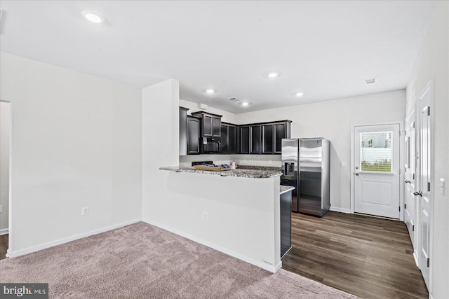 17324 Mary Adams Ave, Bowling Green, VA 22427 - kitchen featuring stainless steel fridge, dark cabinets, baseboards, light stone counters, and a peninsula