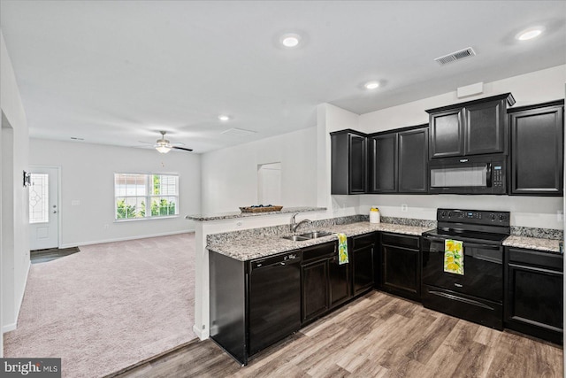 17324 Mary Adams Ave, Bowling Green, VA 22427 - kitchen featuring black appliances, dark cabinetry, a sink, light stone counters, and a peninsula