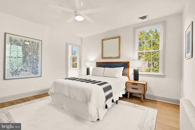 3520 28th St NE, Washington, DC 20018 - bedroom with wood finished floors, baseboards, a ceiling fan, and radiator