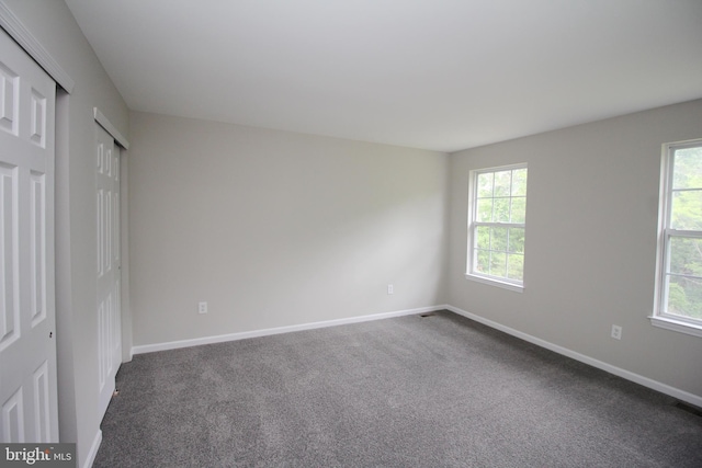 7 E Edgewater Ct, Sicklerville, NJ 08081 - unfurnished bedroom with multiple windows, dark colored carpet, and baseboards